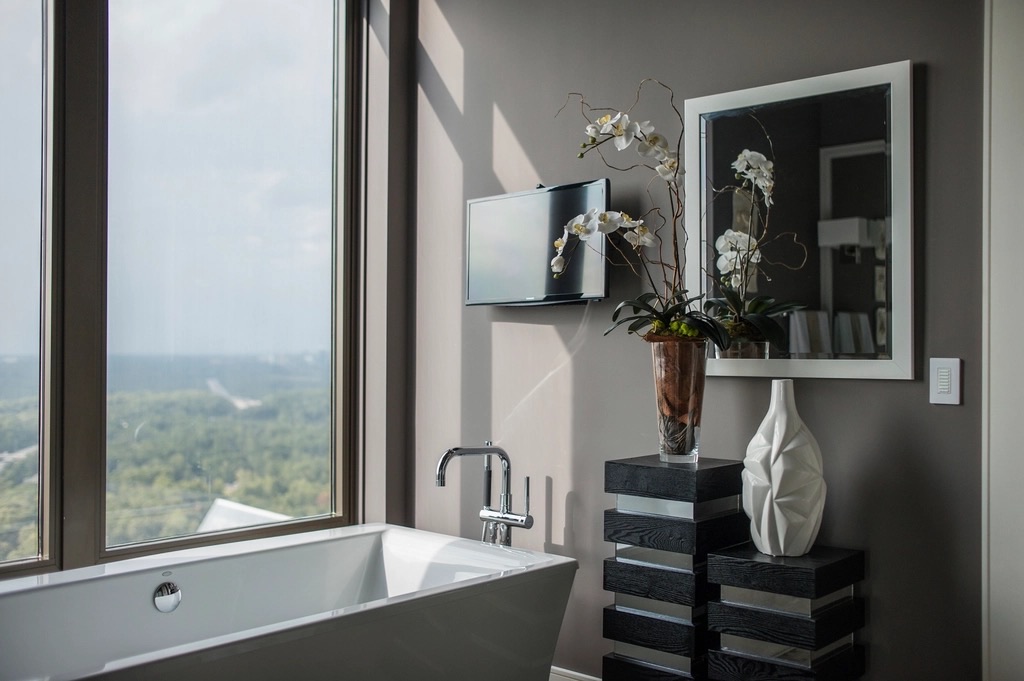 Principal bathroom with a freestanding bath set against full-height glazing